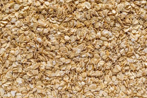Background of oatmeal. Daylight. Throughout the frame are oatmeal flakes.Diet Stock Photos