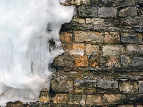 Background old brick wall with big icicle, texture. Vintage Stock Photos