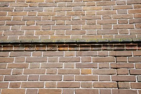 The background is an old brick wall is made of red ceramic bricks. Stock Photos
