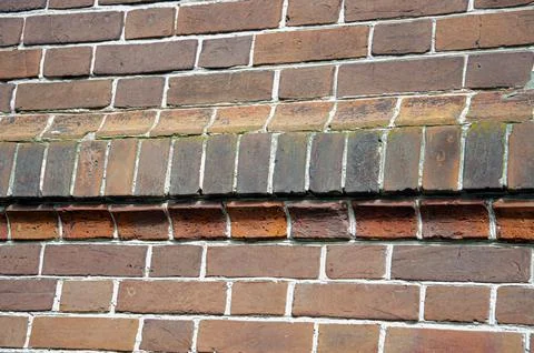 The background is an old brick wall is made of red ceramic bricks. Stock Photos