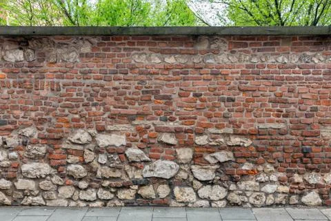 Background old brick wall with small and big stones Stock Photos