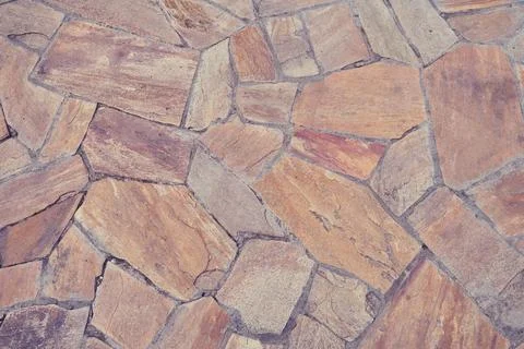 Background of old brown tiles made of irregular shaped stones Stock Photos