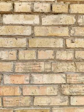 Background of Old Yellow Brick Wall with Weathered Blocks in Vertical Orienta Stock Photos