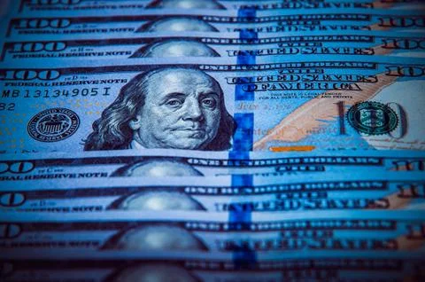The background of a one hundred dollar bill. Style blue light. Stock Photos