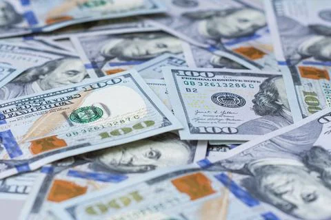 Background of one hundred dollar bills scattered on a flat surface. US cash.. Stock Photos