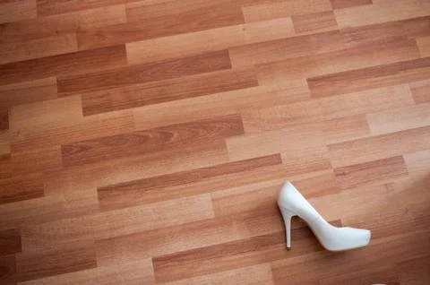 Background, one white shoe of the bride lies on the plank floor Stock Photos