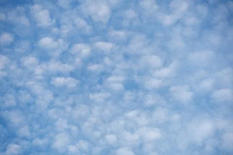 Background Pattern - Bright Blue Sky with Scattered Fluffy White Clouds Stockfoto's