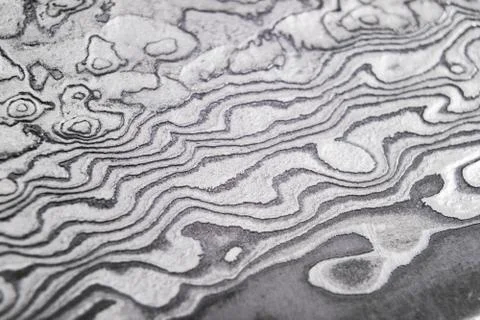 Background with pattern of damask steel. Close up. Macro shot of a damascus k Stock Photos