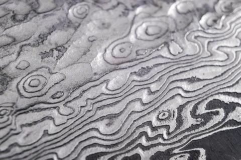 Background with pattern of damask steel. Close up. Macro shot of a damascus k Stock Photos