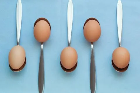 Background pattern of eggs leaning on spoons pastel colors Foto stock