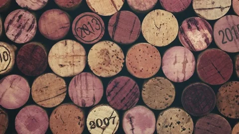 Background pattern of many assorted stacked used red wine corks, close up, pan Stock Footage 154031220
