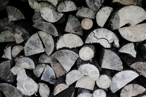 Background pattern of stacked split firewood logs wall texture Stock Photos