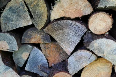 Background pattern of stacked split firewood logs wall texture Stock Photos