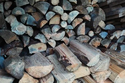Background pattern of stacked split firewood logs wall texture Foto stock