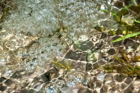 Background of pebbles seen through rippling water Stock Photos