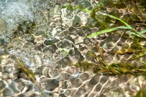 Background of pebbles seen through rippling water Stock Photos