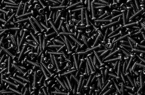 Background pile of shiny black screws Stock Photos