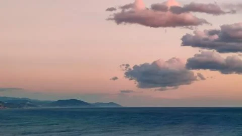 Background of pink clouds in evening sky over sea, twilight fairy sunset, copy Stock Photos