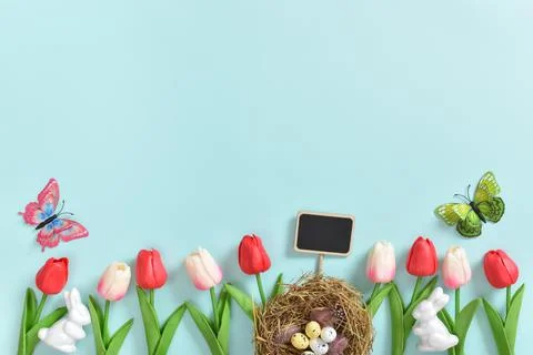 Background with rabbit ears, Easter eggs and tulip flowers. Stock Photos