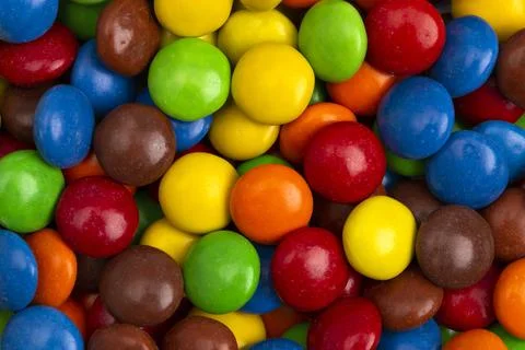 A Background of Rainbow Colored Candy Coated Chocolate Buttons Foto stock