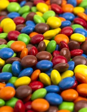 A Background of Rainbow Colored Candy Coated Chocolate Buttons Stock Photos