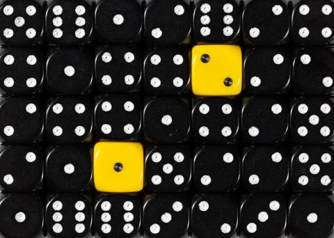 Background of random ordered black dices with two yellow cubes Stock Photos