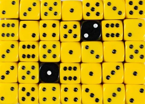 Background of random ordered yellow dices with two black cubes Stock Photos