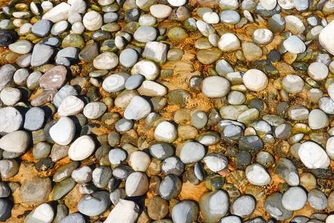 Background of random pattern of stones in shallow pool directly below Stock Photos