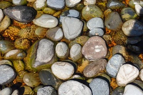 Background of random pattern of stones in shallow pool directly below Stock Photos