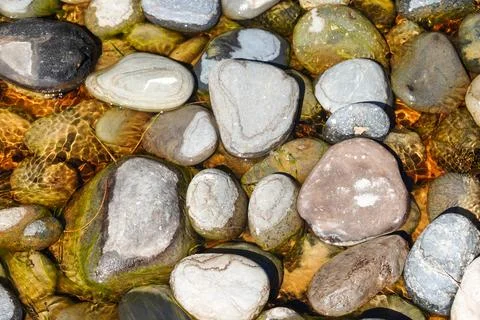 Background of random pattern of stones in shallow pool directly below Stock Photos