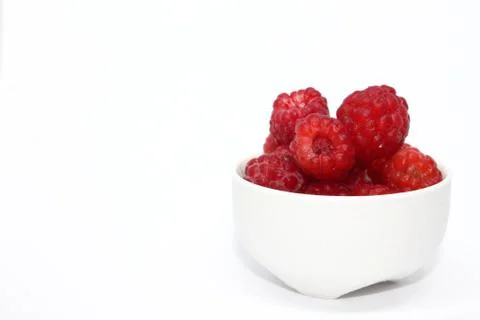 Background raspberry berry in a white cup isolated. Healthy eating concept Stock Photos