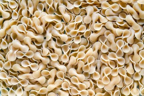 Background of raw pasta spread out on the table, topview Stock Photos