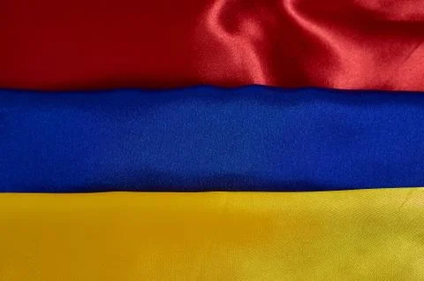 Background red, blue, yellow satin fabric with pleats Stock Photos