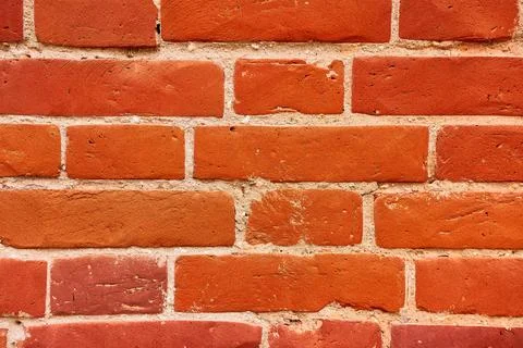 Background of a red brick wall with cement seams. Stock Photos