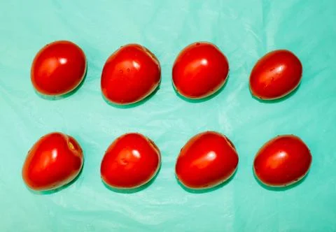 Background of red ripe tomatoes, pattern on turquoise background. Stock Photos