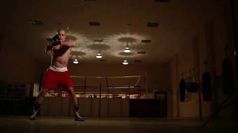 On the background of the ring at the gym, the boxer performs the dynamic Video stock 83949870