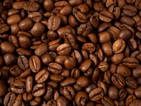 Background from roasted coffee beans. Scattered coffee beans. Stock Photos