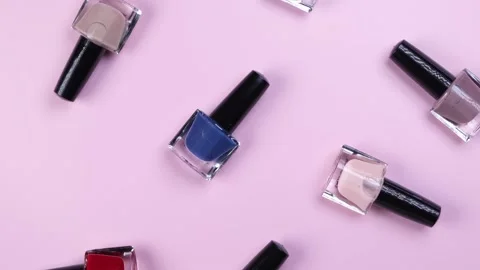 Background of rotating bottles o nail polish on a pink background Stock Footage 221582592