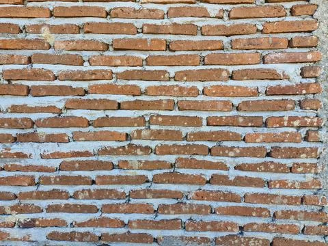 Background of a rough brick wall with uneven cement plaster, highlighting i.. Stock Photos