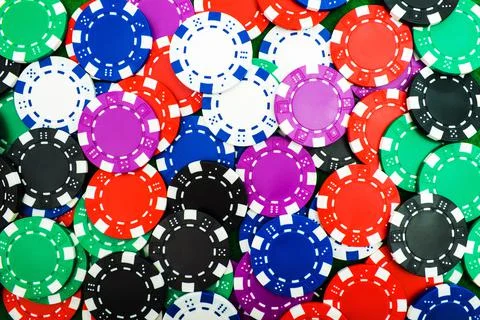 Background of round poker chips is a close-up of different denominations. Stock Photos