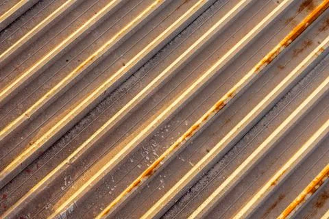 Background of rusty old metal panel of the roof of an old factory with diagon Stock Photos