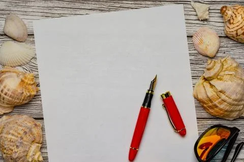 Background with seashells a white sheet of paper with a red pen and sunglasse Stock Photos