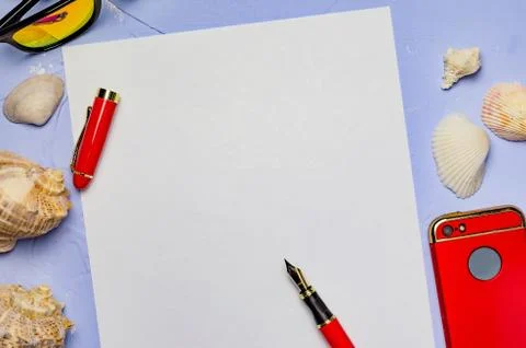 Background with seashells a white sheet of paper with a red pen and a red pho Stock Photos