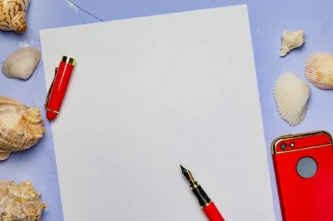 Background with seashells a white sheet of paper with a red pen and a red pho Stock Photos