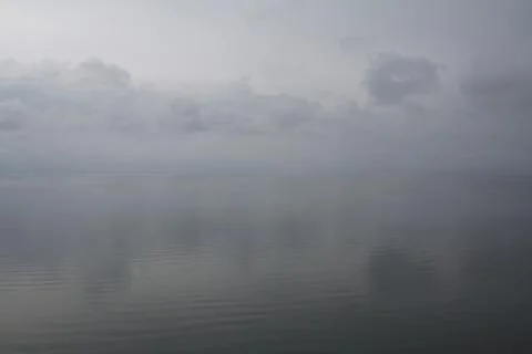 Background. Serene view of calm waters under cloudy sky Stock Photos