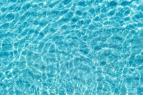 Background shot of aqua water surface. Swimming pool with sunny reflections. Stock Photos