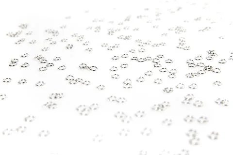 Background of silver colored jump rings scattered over white very shallow d.. Stock Photos