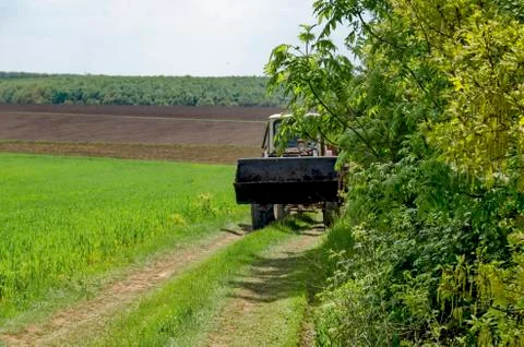 Background of sky, clouds, field  and wheeled tractor Stock Photos