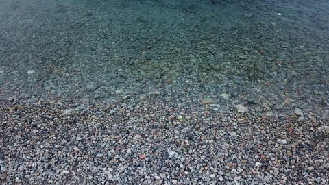 Background - Slow Flight with top down view over pebbles and sea Stock Footage 104490332