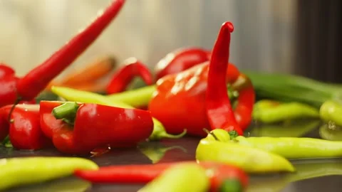 Background slow motion video of green and red chili peppers falling on the table Stock Footage 296362074